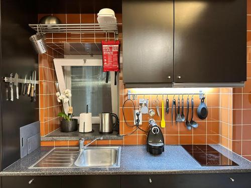 a kitchen with a sink and a counter with utensils at Apartamento acolhedor no centro da cidade, com pátio privado. in Angra do Heroísmo