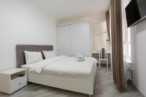 biała sypialnia z łóżkiem i telewizorem w obiekcie Apartament in the Center Area w mieście Sectorul Botanica
