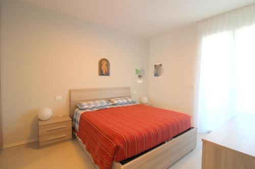 een kleine slaapkamer met een bed en een raam bij Condominio Meit in Lido di Jesolo