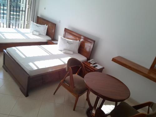 a bedroom with a bed and a table and chair at WILIVINA HOTEL in Dar es Salaam