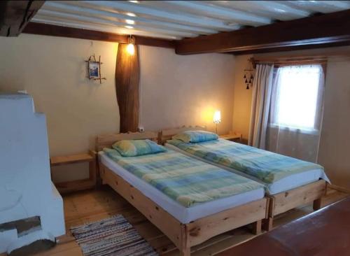 um quarto com uma cama grande num quarto em sodyba Vieversynė em Duokiškis