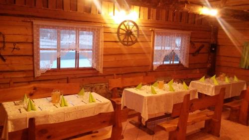 uma sala de jantar com mesas e cadeiras num camarote em sodyba Vieversynė em Duokiškis
