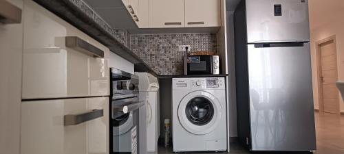 uma cozinha com máquina de lavar e secar roupa num quarto em Logement Chic, résidence azaléa - Alger em Draria