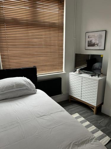 a bedroom with a bed and a desk and a window at ChaRloHub 01 in Coventry