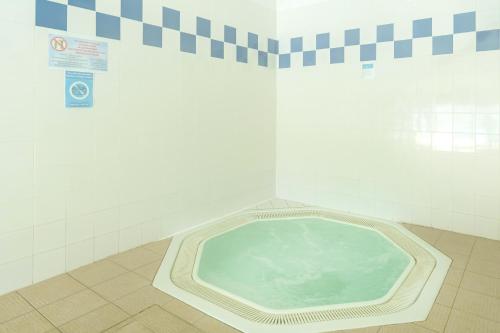 Gîte Le coeur des Landes في Cassen: حوض استحمام ساخن في الحمام مع وضع علامة على الحائط