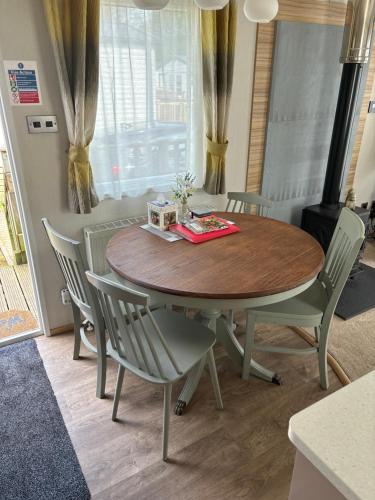 a dining room table and chairs with a wooden table and a table at Squirrel Lodge (Unit 7) in Carlisle