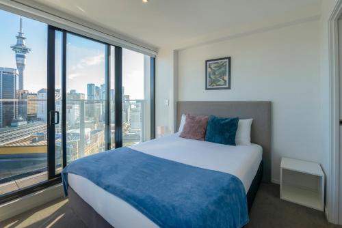 a bedroom with a bed and a large window at Apartment with Brilliant views in Auckland CBD in Auckland