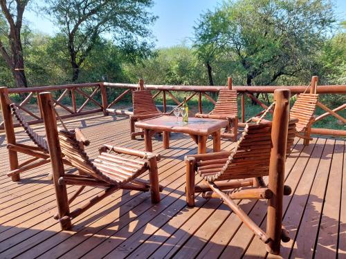 a wooden deck with a table and chairs on it at Khumbula iAfrica 2 in Marloth Park