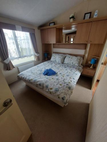 um quarto com uma cama com uma camisa azul em Seaside caravan Hoburne Naish Holiday Park Naish Common 83 em New Milton
