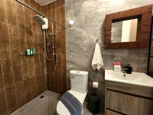 een badkamer met een douche, een toilet en een wastafel bij Skeyndor Health & Resort in Na Jomtien