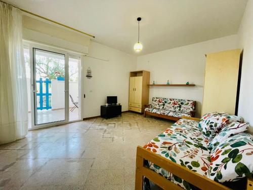 ein Wohnzimmer mit einem Bett und einem Sofa in der Unterkunft il Profumo del Mare a 150 mt dalla spiaggia bandiera blu in Torre Ovo