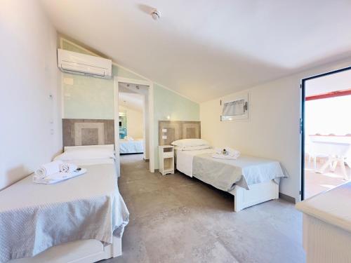 a room with two beds and a mirror at Hotel Marconi in Sperlonga
