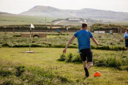 a young man playing with a soccer ball in a field at The Piglet 4 in Yarmouth
