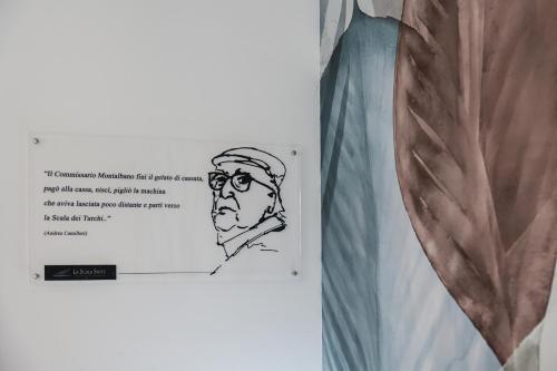 a drawing of a man with glasses on a wall at La Scala Suite in Realmonte