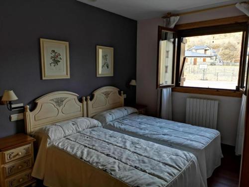 Schlafzimmer mit einem Bett und einem Fenster in der Unterkunft Apartamentos Casa Boira 3000 in Gavín