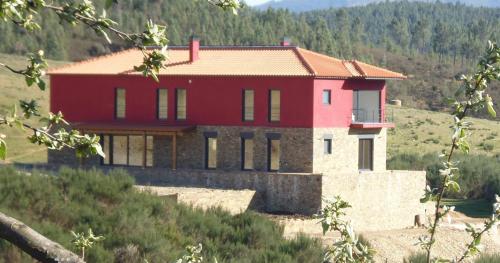 a red house on the side of a hill at Quinta do Favacal - Agroturismo - Serra da Estrela in Casegas