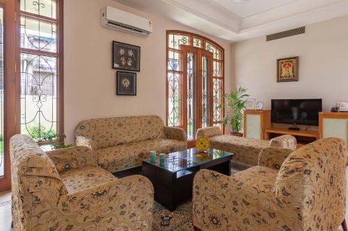 a living room with couches and a coffee table at Krishnalaya Mansion by VEO - Part of StayVista in Jaipur