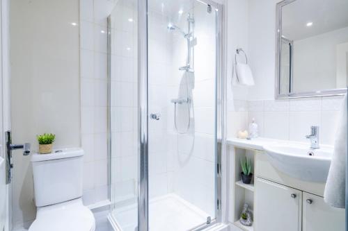 baño blanco con ducha y lavamanos en InSpires House Contractors, families, Wifi, Free Parking Town Centre, en Hemel Hempstead