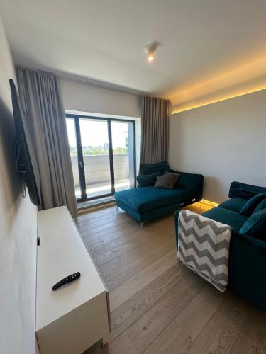 ein Wohnzimmer mit einem Sofa und einem TV in der Unterkunft Apartament lux cotroceni in Bukarest