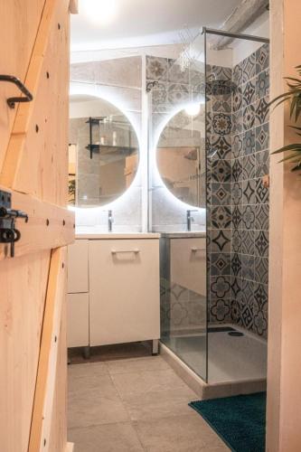 une salle de bain avec une douche avec une porte vitrée dans l'établissement Le grenier de flo, à Florensac