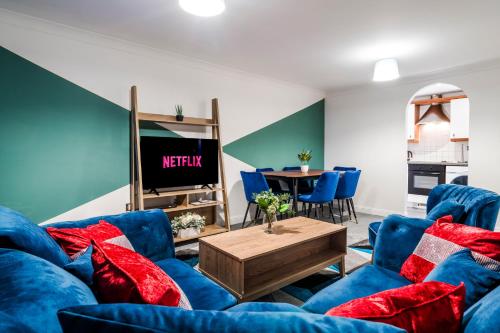 uma sala de estar com sofás azuis e uma mesa em InSpires House Contractors, families, Wifi, Free Parking Town Centre em Hemel Hempstead