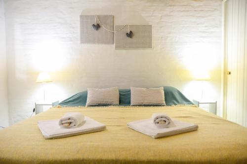 Una cama con dos toallas encima. en Casa Patagonica en Puerto Madryn