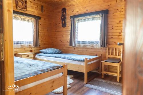 um quarto com 2 camas num chalé de madeira em Rum Haz em Borzont