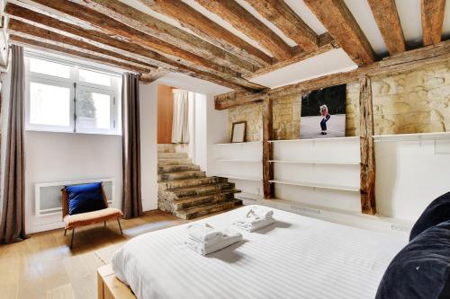 une chambre avec un lit et un mur en pierre dans l'établissement Pick A Flat's Apartment in Louvre - Rue Saint-Anne, à Paris