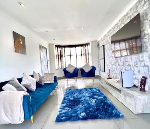 a living room with a blue couch and a blue rug at The Grey Mansion in Manchester