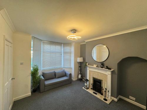 a living room with a couch and a fireplace at Home In Coventry in Coventry