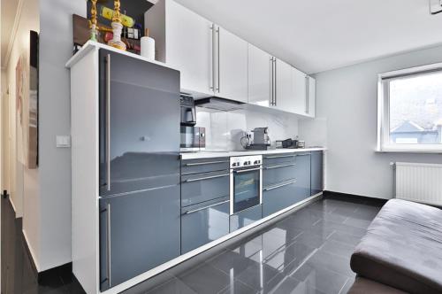 une cuisine avec des armoires blanches et des appareils bleus dans l'établissement Esch/Alzette apartment, à Esch-sur-Alzette