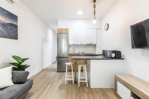 a kitchen with a stainless steel refrigerator and stools at Apartamentos a 5 minutos del centro de Madrid 4P in Madrid