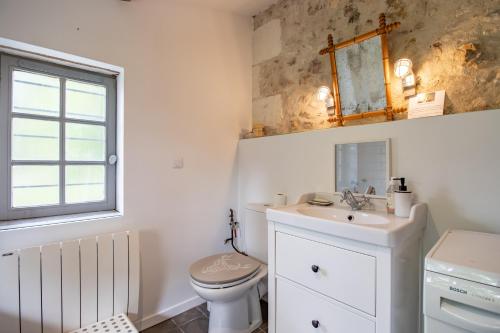 a bathroom with a toilet and a sink and a mirror at Nature et authenticité in Saint-André-de-Double