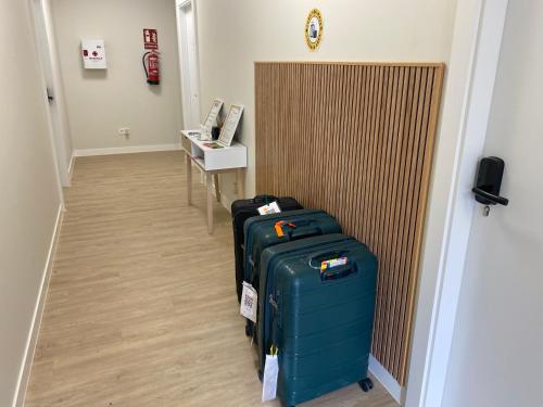 a hallway with two pieces of luggage and a desk at Apartamentos TARELA Porriño in Porriño