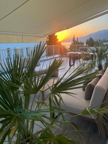 a patio with a couch and a sunset in the background at Sunset Huus in Starigrad-Paklenica