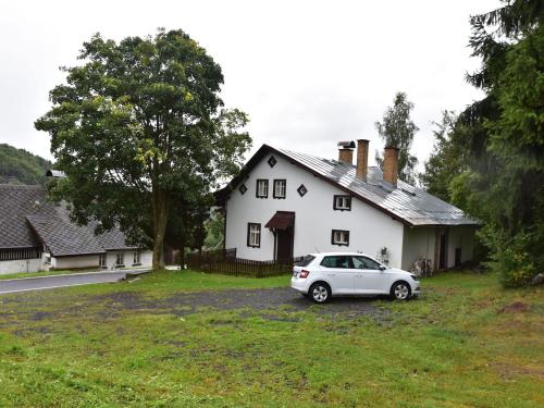 um carro branco estacionado em frente a uma casa branca em Holiday home in a quiet authentic mountain village with a view of the surrounding hills em Zlatá Olešnice