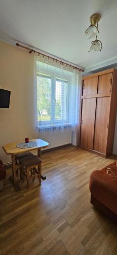 an empty living room with a table and a couch at 8-emka Apartament in Stronie Śląskie