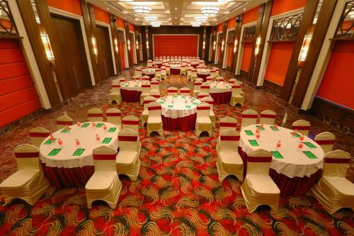 a row of tables and chairs in a banquet hall at Grand Serenaa Hotel & Resorts, Auroville in Auroville