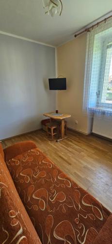 uma sala de estar com um sofá e uma mesa em 8-emka Apartament em Stronie Śląskie