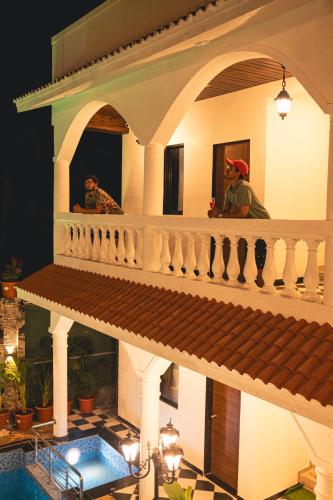 two people sitting on the balcony of a house at Sapphire Mansion in Alibag