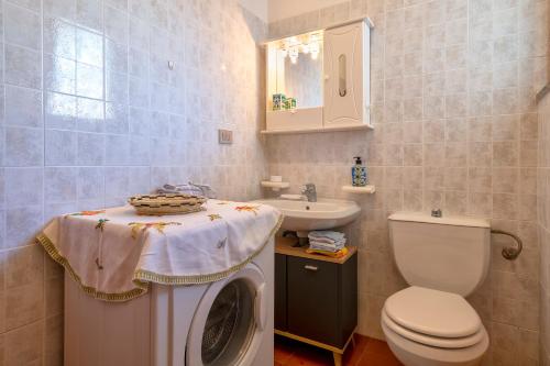 een badkamer met een wasmachine en een wastafel bij Casa Sara Lu Bagnu in Castelsardo