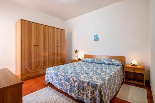 een slaapkamer met een bed en een houten kast bij Casa Sara Lu Bagnu in Castelsardo