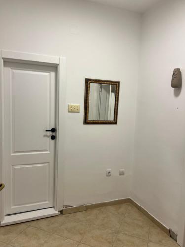 eine weiße Tür mit einem Spiegel an einer weißen Wand in der Unterkunft Apartman Vučko in Rafailovici