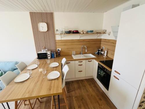 une petite cuisine avec une table et des chaises en bois dans l'établissement Standing***Appartement 4 personnes, à Reignier-Ésery