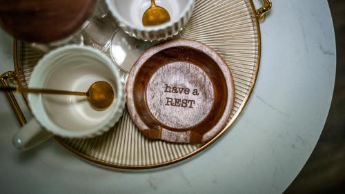 ein Teller, auf dem neben einer Tasse Kaffee eine Pause geschrieben ist in der Unterkunft Howfield Hotel in Merthyr Tydfil