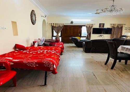 ein Wohnzimmer mit einem roten Bett und einem Sofa in der Unterkunft Best Individual Home stay Near Apollo Jubilee Hills in Hyderabad
