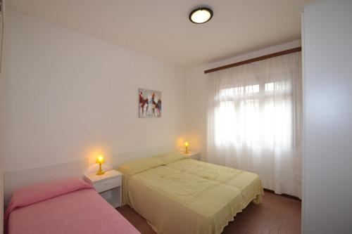 1 Schlafzimmer mit 2 Betten und 2 Kerzen auf Tischen in der Unterkunft Comfy flat 80m from the beach - Beahost in Bibione