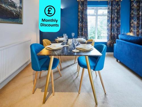 ein Esszimmer mit einem Tisch und blauen Stühlen in der Unterkunft Modern Comfort 2BR Apartment - FREE Parking - FAST Internet in Oadby
