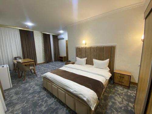 En eller flere senge i et værelse på HOTEL KARVON SHAHRISABZ