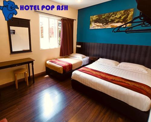 a hotel room with two beds and a mirror at HOTEL POP ASH in Brinchang